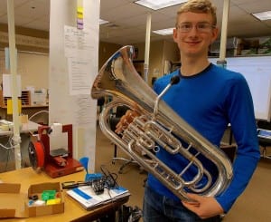 Skipper Erickson holds his euphonium next to the 3-D printer he used to make the instrument's mouthpiece. Photo/Angela Denning