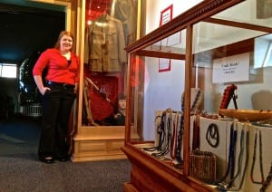 Museum Director, Brittany Zenge, stands next to a display of a WWI uniform. Photo/Angela Denning