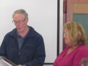 Petersburg Pilot publisher Ron Loesch reads from a plaque he presented to out-going borough clerk Kathy O'Rear Monday.