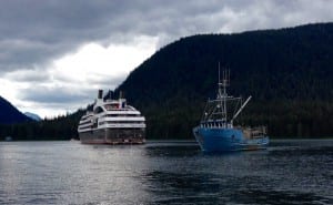 A fishing boat passes in front of the French mega-yacht L'Austral. Photo/Angela Denning