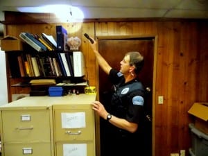 Police Officer, Derk Thorsen, takes a close look at the buckling ceiling in the squad room of the municipal building.(Joe Sykes)