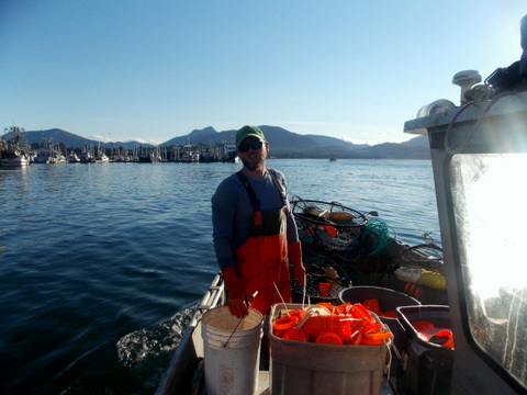 Leif Mattern cleans crab pots at the bow of the boat.(Joe Sykes)