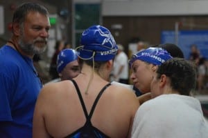 Petersburg swimmers Molly Parks, Alyssa Guthrie, Isabel Ith, and Mariah Taylor check out swim details on paper as Coach Andy Carlisle looks on. Photo/Brad Taylor Coach Andy Carlisle 