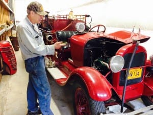 Jack Slaght points to the engine he overhauled in the 1928 Model A fire truck. Photo/Angela Denning
