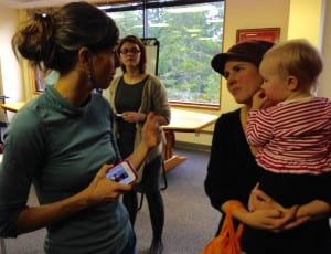 Melena Marvin (left) explains why she supports Bernie Sanders to non-committed voter, Molly Taiber. Caucus organizer Annette Wooton looks on. Photo/Angela Denning