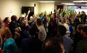 Petersburg's Bernie Sanders supporters hold up green slips of paper to be counted at the Democratic caucus. Photo/Angela Denning