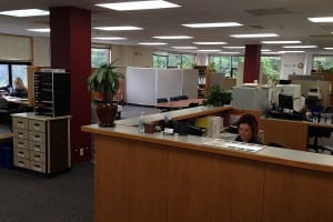 Stacy Luhr sits at the desk of the borough's new finance office in the second floor of the Hallingstad-Peratrovich building. Photo/Angela Denning