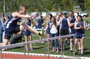 Casey Bell competes in the hurdles with his teammates watching. Bell took first in both the 110 and 300 hurdles in Ketchikan. (Photo courtesy of Brad Taylor)