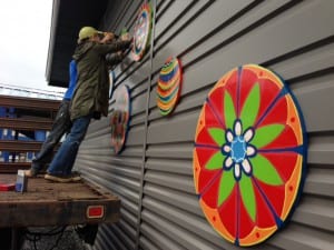 Artist Pia Reilly installs new paintings to the outside of the Rae C. Stedman Elementary with help from Rans McIntosh. Photo/Angela Denning