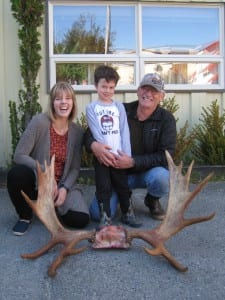 Rocky Littleton poses along with Tessa Bergman, and grandson Cedar Littleton, age 4 with moose antlers from the legal bull he took this season. Photo courtesy of ADF&G