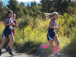 Julia Murph, left, chases Meghyn Parker at the bottom of the old water tower hill behind Petersburg's airport Saturday.