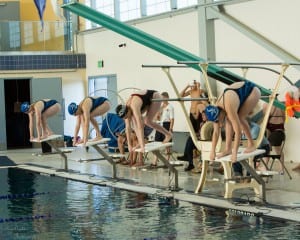 Three Petersburg Viking girls in blue and black get set to race the 100 yard freestyle. (from left) Kate Bisset, Maria Pfundt, Alisa Guthrie. Photo/Tanya Somerville,www.SeaprintsPhotography.com