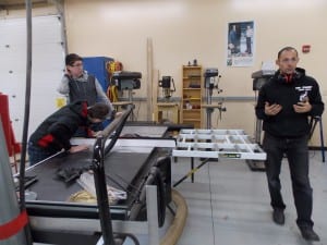 On the left, PHS sophomores Colby Spears and Joshua Coonrad (leaning over) prepare for a demonstration of the high school's new SawStop as shop teacher Dave Owens explains.