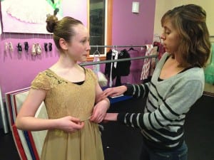 13-year-old Rose Quitslund, who will play Clara in the Nutcracker, gets help with a costume from MDT Studio dance teacher Kathleen Boggs. Photo/Angela Denning