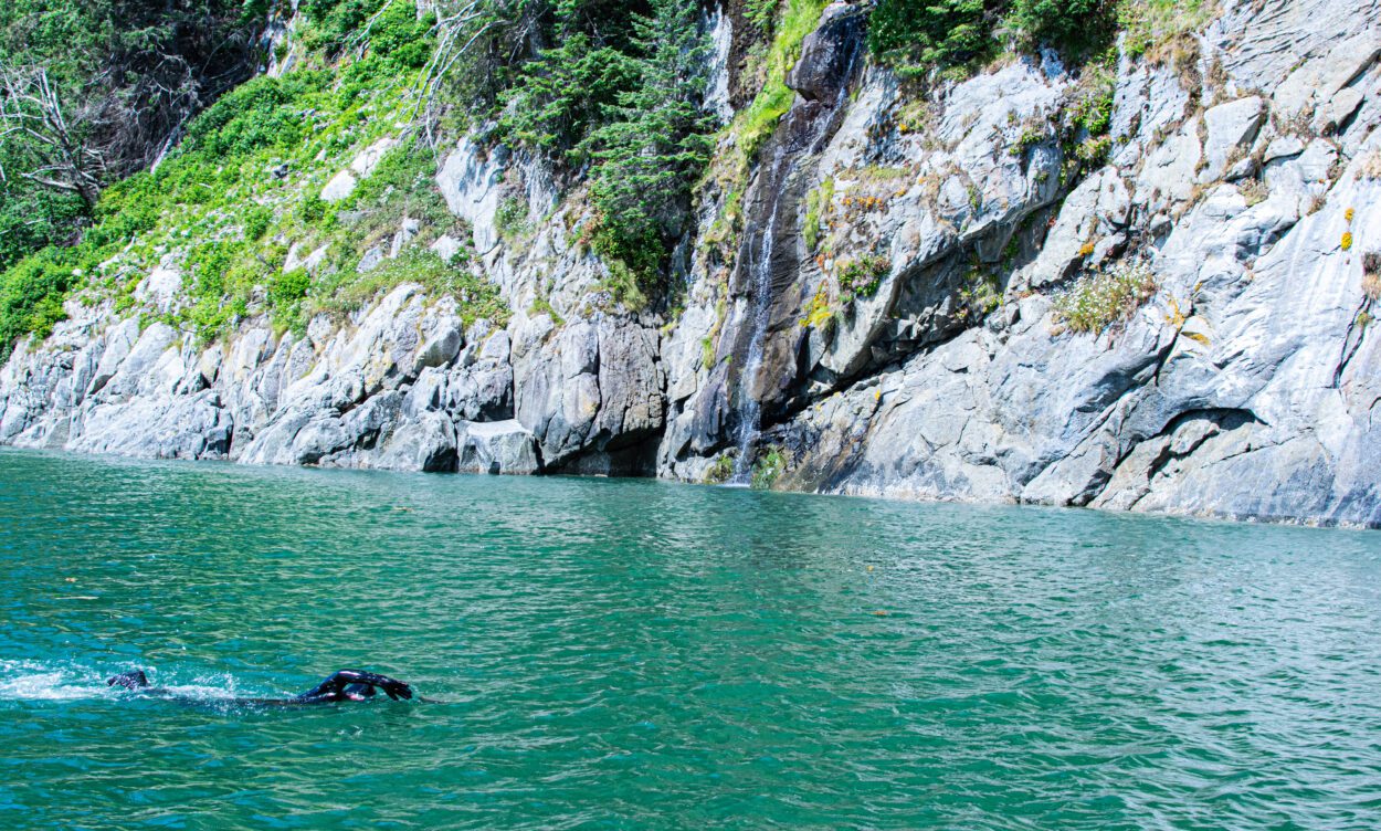 Andrew Simmonds swimming up to the cliffside on